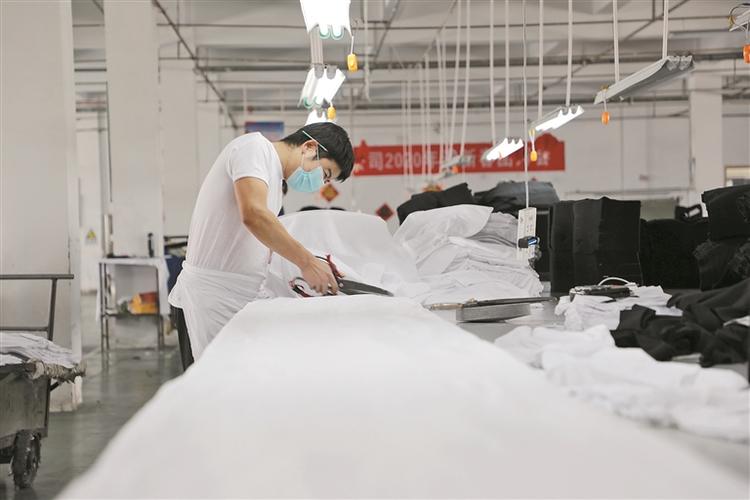 图④ 在新疆芳婷针纺织有限责任公司针织厂裁剪车间,工人正在裁剪服装